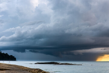 Huge offshore thunder storm and rain at sunset over a tropical ocean