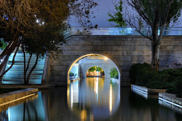 Illuminated arch over canal in Baku at evening time