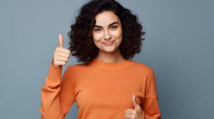 Image of beautiful brunette woman wearing casual clothes winking and showing thumbs up at camera