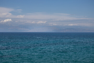 Ionian sea and a cloudy sky above mountains, Corfu, Greece