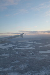 Flying over  white snowy landscape with many forests in Finland