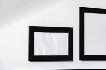 Set of black frames on white wall with copy space