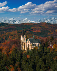 Levoca, Slovakia - Aerial view of Basilica of the Blessed Virgin Mary on a bright autumn day with the snowy summit of Marianska mountain of the High Tatras and blue sky with clouds at background
