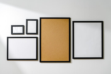 Set of black frames on white wall with copy space