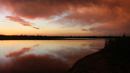 Las luces del ocaso siguen pintando las nubes reflejadas en el agua dulce de los ríos...