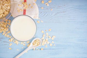 Glass of fresh milk on light blue wooden table background, space for text.