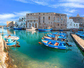 Old port of Monopoli in Apulia, southern Italy: view of the old town with fishing and rowing boats.