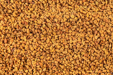 Fenugreek seeds as background, top view. Brown fenugreek seeds, methi dana, helba or shambala.