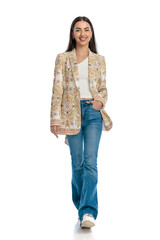 happy fashion woman holding hand in pocket, smiling and walking