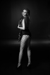 Low key portrait of woman in stockings in a grid in black and white