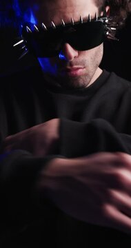 vertical video of confident casual guy in black sweatshirt pointing fingers forward and inviting, crossing arms, looking to side, nodding and dancing on black background