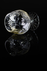 Overturned luxury glass with rum on a black background
