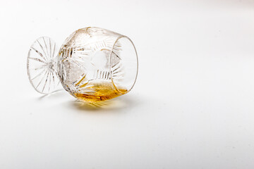 Overturned luxury glass with rum on a white background