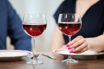 Two glasses of wine in a close-up on a blurred background.