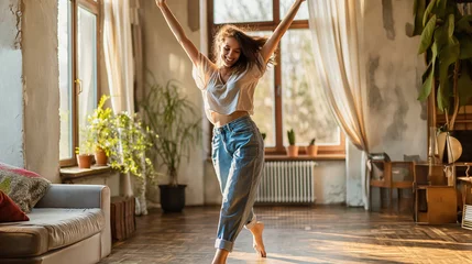 Fototapeten Hobby-Based Movement for Physical and Mental Health. Dance for mental health benefits, outlet for emotions. Young woman joyfully dancing alone at home. © irissca