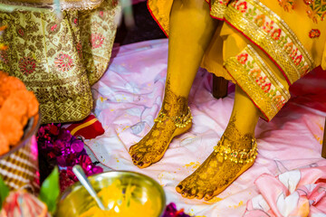 Indian Hindu pre wedding yellow turmeric Haldi ceremony feet close up