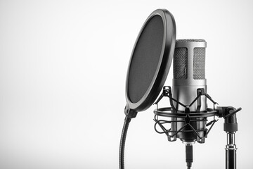 Condenser professional microphone with black pop filter on stand. Copy space.