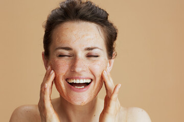 Portrait of smiling modern 40 years old woman with face scrub
