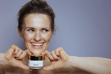 smiling woman with cosmetic cream jar