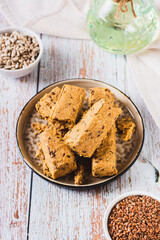 Pieces of halva with flax seeds on a plate on the table vertical view