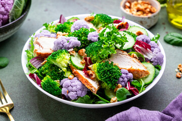 Healthy salad from purple cauliflower, broccoli, chicken breast, fresh cucumbers, onion, radicchio,...