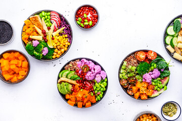 Vegan buddha bowls assortment with pumpkin, quinoa, tomatoes, spinach, avocado, radish, soybeans,...
