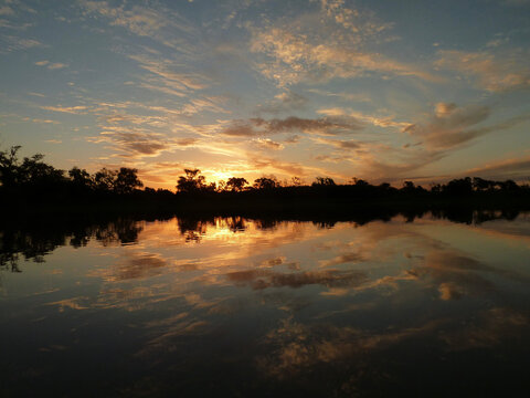 El rio de las islas santafesinas de America del Sur se trasforma en un espejo cuando cae el sol acompa&ntilde;ado de nubes de colores.