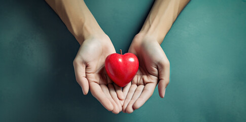 Hands cradling a shiny red heart, symbolizing care, health, and love on a teal background