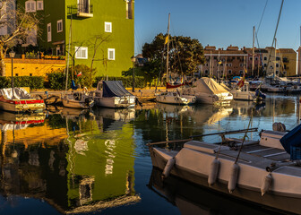 Port Saplaya w Hiszpanii. Łodzie, jachty, motorówki, małe łódki w przystani i kolorowe domki.