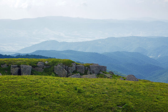 boulders on the grassy hillside. mountainous rolling landscape in summer. clouds on the sky