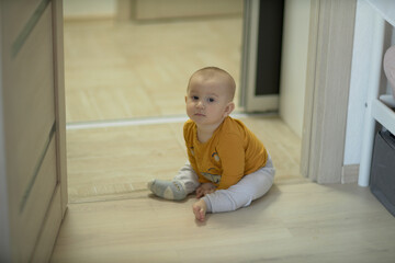 Naklejka premium A baby is a happy baby in the first months of life, crawling around the house, smiling.
