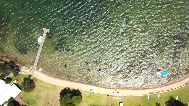 Raffertys resort beach on Lake Macquarie lakeshore waterfront – aerial top down.
