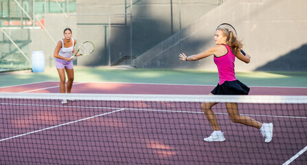 Fototapeta na wymiar Caucasian woman wearing in pink t-shirt and skirt playing tennis match during training on court