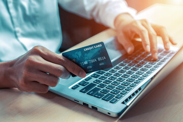 Young man use credit card for shopping payment online on laptop computer application or website....