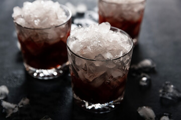 Alcoholic cocktail with ice on a dark background close-up