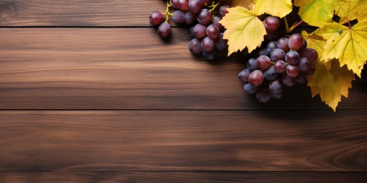 Wooden table with grape and autumn leaves. Flat lay, copy space.
