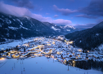 Aerial view of beautiful alpine village at cold winter night. Kranjska Gora, Slovenia. Top drone...