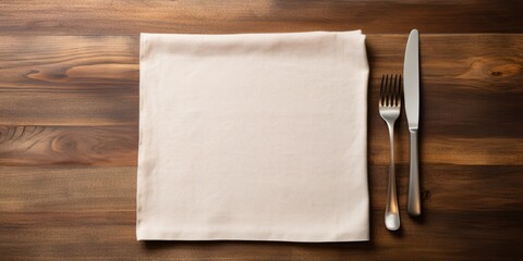 Top view of a wooden table with a wood cutting board, linen napkin, knife, and fork, along with empty space for copying