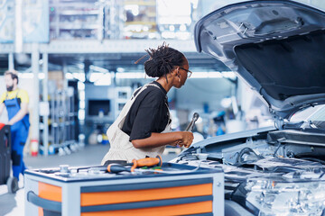 Car service serviceman expertly examines engine using advanced mechanical tools, ensuring seamless...