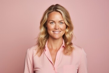 Portrait of a smiling businesswoman in a pink shirt on a pink background