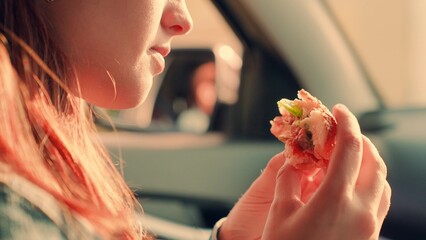 Delicious satisfy food, Girl eat burger inside car. Hungry girl eat fast food burger on car seat....