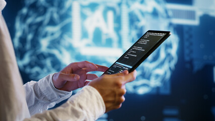 IT developer writing artificial intelligence script code in startup workspace on tablet terminal. Experienced programmer doing maintenance work in high tech facility updating AI systems