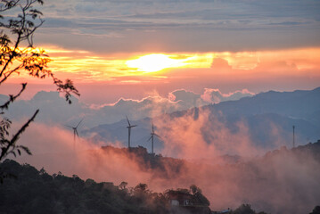 Mountain Sunset: Costa Rican peaks meet the twilight with distant wind turbines, a serene alliance...