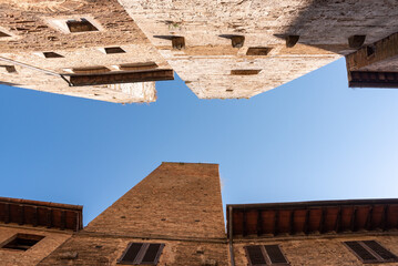 In the streets of San Gimignano, view on the towers Pettini and Salvucci - obrazy, fototapety, plakaty