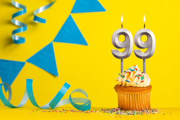 Birthday candle number 99 with cupcake - Yellow background with blue pennants