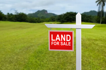 land for sale plate sign, green lawn background.