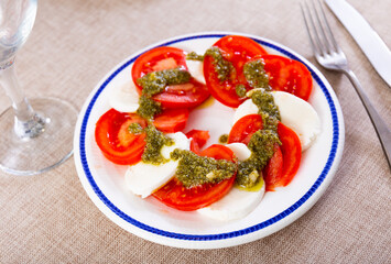 Traditional snack of Italian cuisine is Caprese with basil and Pesto sauce