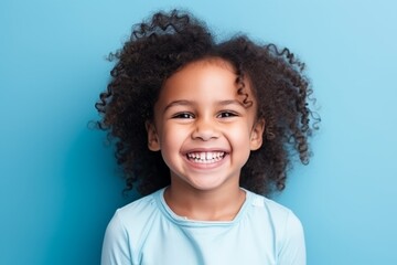 Portrait of a cute little african american girl smiling against blue background