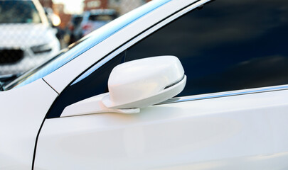 car side mirror reflecting cityscape, symbolizing perspective and reflection in urban life