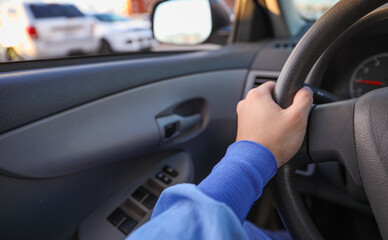 hand gripping a steering wheel while driving a car, focused and in control